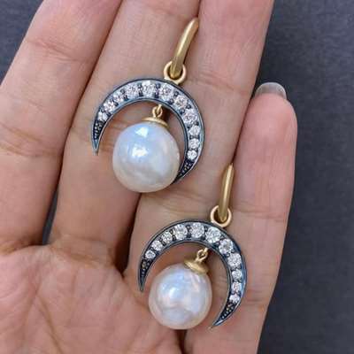A pair of 18k gold earrings Set with 22 old cut white diamonds totaling 1.31ct with the organic glow of two baroque pearls weighing 25.27ct in total.