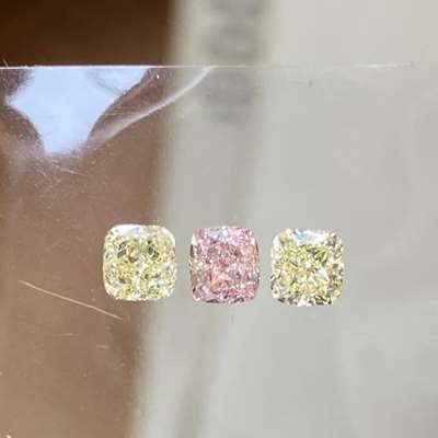 0.27cts GIA certified natural fancy Orangy pink vs2 clarity cushion shape diamond paired with 0.49cts total weight pair of natural fancy light yellow vs1 clarity cushion shape diamond layout