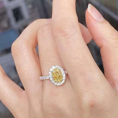 1.20ct GIA Certified Natural Fancy Light Brownish Yellow VS1 Clarity Oval Shape Diamond Set In 18k Gold Ring Along With White Diamonds.