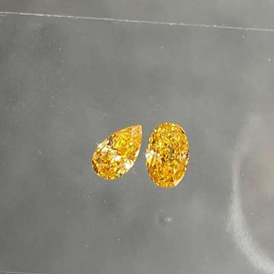 0.22cts GIA certified Natural Fancy vivid yellow-orange vs2 clarity oval shape diamond paired with 0.17cts GIA certified natural fancy vivid yellow orange pear shape diamond.