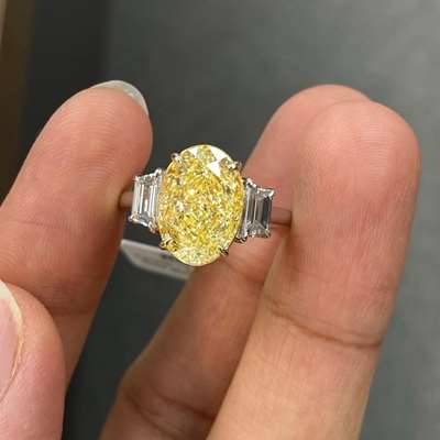 Its a 5.02ct GIA Certified Natural Light Yellow (w to x range) SI1 Clarity Set In 18k Gold Along With 0.53ct Total Weight Matching Pair Of Natural Trapazoid shape white diamonds. 