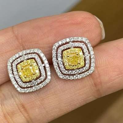 Wrapped in a classic double halo and set in rich 18k gold, they glow with a soft golden warmth that feels effortless and elegant.