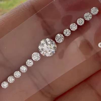 At the centre sits a 0.70cts natural I color SI2 old European cut diamond, surrounded by 0.54cts total weight of 12 natural GH color SI clarity old cut rounds.
