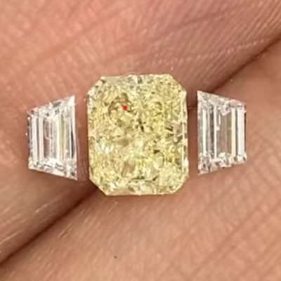 1.01cts GIA certified Natural Light Yellow (W-X range) VVS1 Clarity Radiant Shape Diamond is a radiant beauty, perfectly complemented by 0.29cts total weight pair of Natural E Color VVS2 Clarity Trapezoid Shape Shoulder Diamonds.