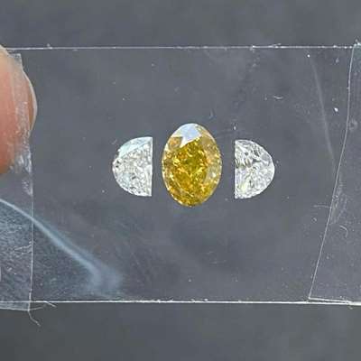  0.71ct oval-shaped greenish-orangish-yellowish brown SI1 CLARITY AND 0.36ct total weight of G color VVS2 clarity half-moon diamonds, 