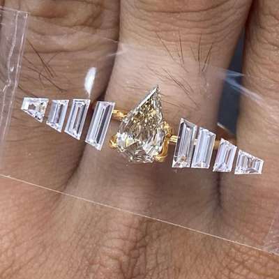 At the center, a 1.13ct step-cut pear diamond (natural peachy brown, SI1 clarity) it’s framed with 8 trapezoid diamonds, VVS2 clarity, GH color, totaling 0.64cts.