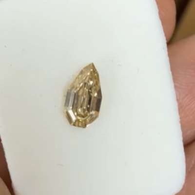A 0.42cts natural champagne brown VS2 clarity step cut pear shape diamond