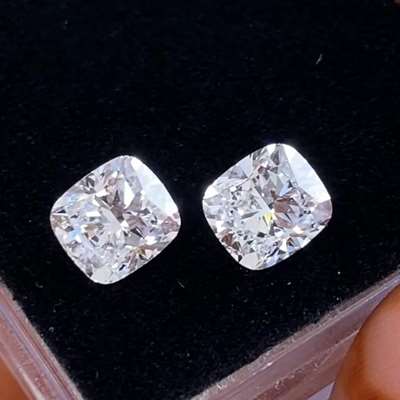 One is 1.01ct in E color and the other is 1.00ct in F color, both GIA certified with VS2 clarity, cushion shaped, and the way they reflect light is just unreal.