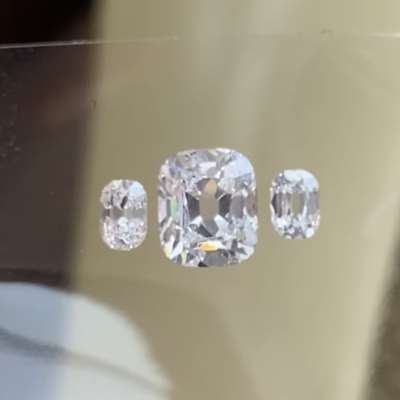 A 1.02cts GIA certified natural G color VVS1 old cut cushion shape diamond sitting between 0.26cts total weight natural F color VS2 old cut oval diamonds, 